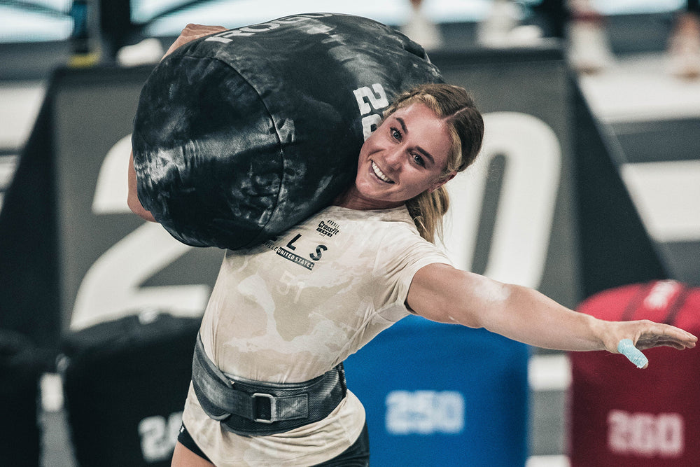 CrossFit Games athlete Brooke Wells lifts a sand bag while wearing athletic clothing