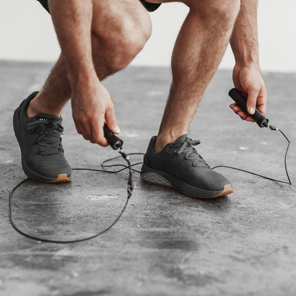 A man prepares to work out by jumping rope and is wearing Dark Grey ripstop cross training sneakers