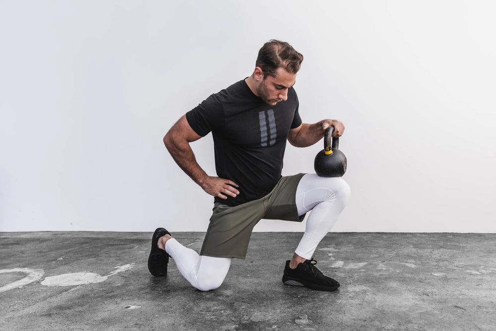 Athletic man working out in midweight compression tights in color white